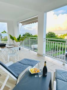 a table with a bowl of food on a balcony at Sweety blue, vue mer in Les Trois-Îlets