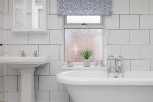 a bathroom with a sink and a tub and a window at Characterful Terrace Retreat in County Durham - Sleeps 6 in Stanley +28 photos