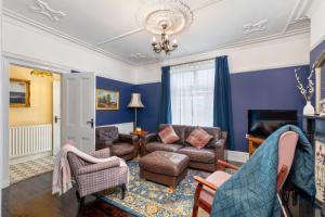 a living room with blue walls and a couch and chairs at Characterful Terrace Retreat in County Durham - Sleeps 6 in Stanley