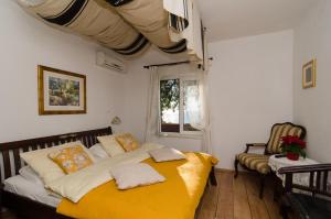 a bedroom with a bed with a yellow blanket at B&B Villa Dubrovnik Garden in Dubrovnik