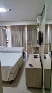 a hotel room with two beds and a tv at Garvey - flat 638 in Brasilia +14 photos