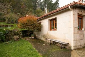 a bench sitting outside of a building with a window at Villa Laudina in Vilaboa