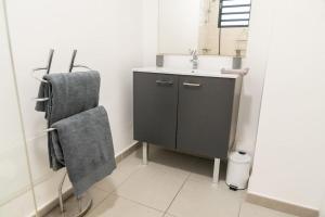 La salle de bains est pourvue d'un lavabo et d'un sèche-serviettes. dans l'établissement Studio avec vue sur mer à l'Etang Z'Abricot, à Fort-de-France 8 autres photos