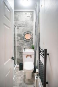 a bathroom with a toilet with a stone wall at Moonlight Residence - Anfield Stadium, Free Parking & Free WiFi in Liverpool