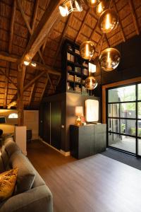 a living room with a couch and a tv at Luxe Hofstede met paardenstalling in Lunteren