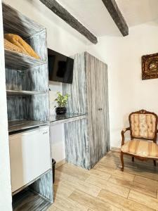 a room with a chair and a tv and shelves at Hotel Boutique Casa Miranda in Querétaro +19 photos