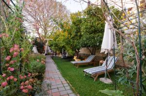a garden with two chairs and an umbrella and flowers at B&B Villa Dubrovnik Garden in Dubrovnik