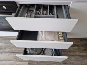 a drawer in a kitchen with white shelves at Dendrarium Park Double Room Apartment in Chişinău