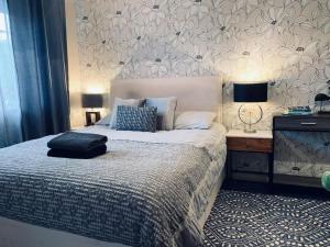 een slaapkamer met een bed en een bureau met 2 lampen bij The Lake House, Woking in Woking
