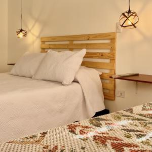 a bedroom with a bed with a wooden headboard at Apartaestudio Loft 203 - UE Home in Duitama