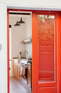 an orange door in a kitchen with a sink at Il Gufo e l' Allodola in Caiazzo