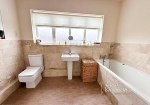 a bathroom with a toilet and a sink and a tub at Oakham ridge in Mansfield +10 photos