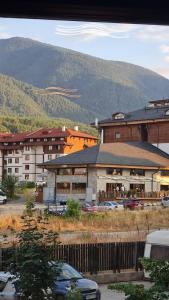 Un gran edificio con coches aparcados en un estacionamiento. en MONTEVERDE Tamplier, en Bansko