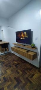 Una sala de estar con un televisor de pantalla plana en una pared. en Sunset Living 317, en Cachoeira do Sul