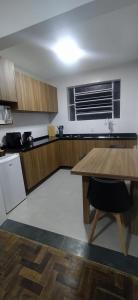 cocina con mesa de madera y encimera en Sunset Living 317, en Cachoeira do Sul 3 fotos más