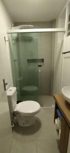 Un baño con inodoro y ducha de cristal. en Sunset Living 317, en Cachoeira do Sul