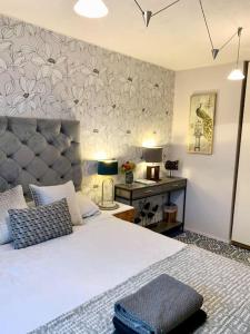 een slaapkamer met een groot bed en een bureau bij The Lake House, Woking in Woking