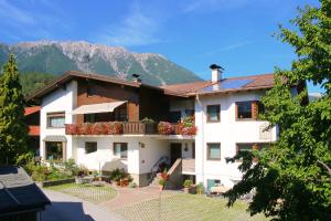 un grande edificio bianco con balcone e montagne di Haus Gamper-Haselwanter a Tarrenz