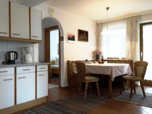 Haus Gamper-Haselwanter في تارينز: مطبخ وغرفة طعام مع طاولة وكراسي