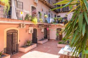 un cortile di un edificio con un mucchio di piante di Borghetto Capuana House a Catania