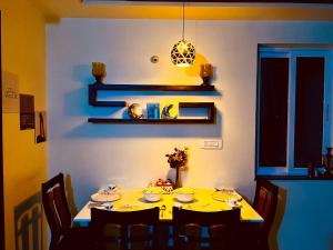 a dining room with a yellow table and chairs at 7 Seasons Palm Suite with Sky Orbit, Balcony, Swimming pool, WIFI, Playground in Rajkot