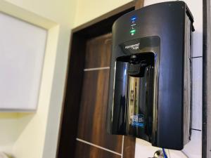 a coffee machine sitting on a counter next to a door at 7 Seasons Palm Suite with Sky Orbit, Balcony, Swimming pool, WIFI, Playground in Rajkot