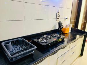 a kitchen counter with a stove top in a kitchen at 7 Seasons Palm Suite with Sky Orbit, Balcony, Swimming pool, WIFI, Playground in Rajkot