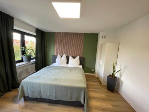 a bedroom with a bed with white pillows and a window at Auszeit am Kurpark I 24h Check-In I WLAN in Bad Salzuflen