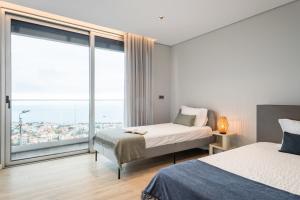 um quarto com 2 camas e uma grande janela em Bayview Villa Retreat no Funchal