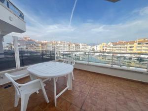 ein weißer Tisch und zwei Stühle auf einem Balkon in der Unterkunft Apartamento A Frente del Canal con Terraza in Empuriabrava