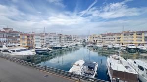 eine Gruppe von Booten, die in einem Hafen mit Gebäuden angedockt sind in der Unterkunft Apartamento A Frente del Canal con Terraza in Empuriabrava + 25 Fotos