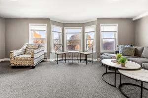 a living room with a couch and chairs and windows at Downtown Beverly Apartment 8 Minutes to Salem and has King Beds in Beverly