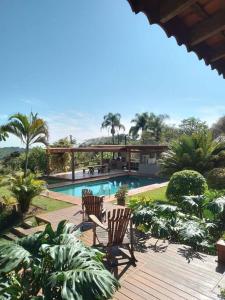 una terraza con 2 sillas junto a una piscina en Sítio Terra Mãe, en Campinas