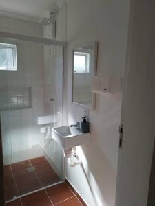 Un baño blanco con lavabo y ducha. en Sítio Terra Mãe, en Campinas