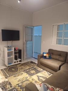 a living room with a couch and a flat screen tv at Casa Da Arlete perto da basilca in Aparecida