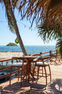 a table and chairs on a beach with the ocean at Monasterio del Viento in Bahia Maracaibo +137 photos