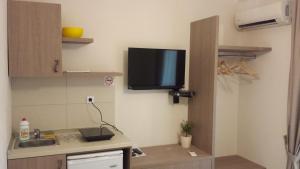 a kitchen with a sink and a tv on the wall at Apartments Fortunella in Budva