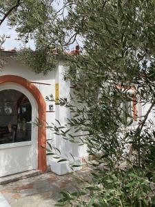 an entrance to a white building with a tree at Resort Dimitris in Alexandroupoli