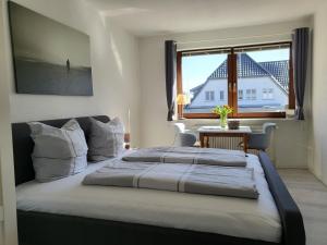 une chambre avec deux lits, une fenêtre et une table dans l'établissement Fewo Glücksiel, à Sankt Peter-Ording
