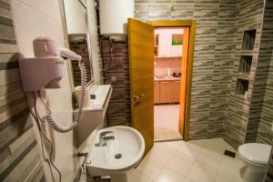 a bathroom with a sink and a toilet and a phone at Apartmani Barović Bečići in Bečići