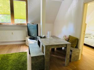 Una sala de estar con una mesa y un televisor. en Neue Pfefferkiste, en Leipzig 54 fotos más
