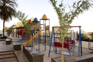 a playground with a slide in a park at 7 Seasons Palm Suite with Sky Orbit, Balcony, Swimming pool, WIFI, Playground in Rajkot