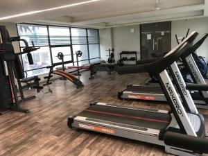 a gym with several treadmills and exercise bikes at 7 Seasons Palm Suite with Sky Orbit, Balcony, Swimming pool, WIFI, Playground in Rajkot