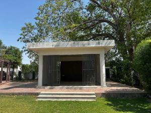 a building with a door in the grass at 7 Seasons Palm Suite with Sky Orbit, Balcony, Swimming pool, WIFI, Playground in Rajkot