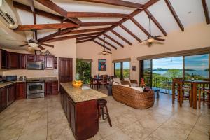 a kitchen with wooden ceilings and a living room at Infinity Pool, Pacific Views & Concierge in Potrero