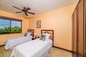 two beds in a room with a window at Infinity Pool, Pacific Views & Concierge in Potrero +17 photos