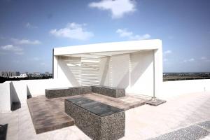 a white building with a bench on a roof at 7 Seasons Palm Suite with Sky Orbit, Balcony, Swimming pool, WIFI, Playground in Rajkot