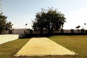 a sidewalk with a tree in the middle of a field at 7 Seasons Palm Suite with Sky Orbit, Balcony, Swimming pool, WIFI, Playground in Rajkot