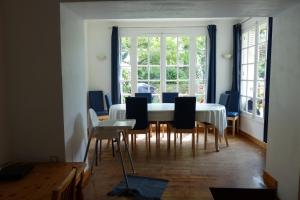 a dining room with a white table and chairs at Maison pour familles et amis in Dinard