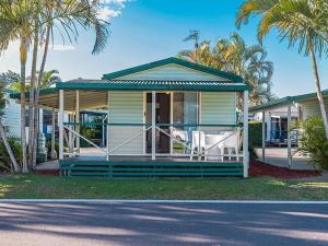 a house with palm trees in front of it at Nambucca River Village by Lincoln Place in Macksville